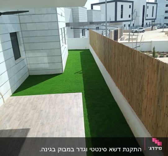 דשא סינתטי לצד גדר עץ בחצר בית